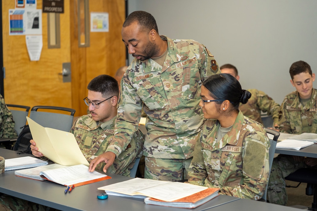 U.S. Air Force Master Sgt. Jaren Durham, 335th Training Squadron weather instructor, reviews students' work at the Weather Training Complex on Keesler Air Force Base, Mississippi, Oct. 16, 2023.