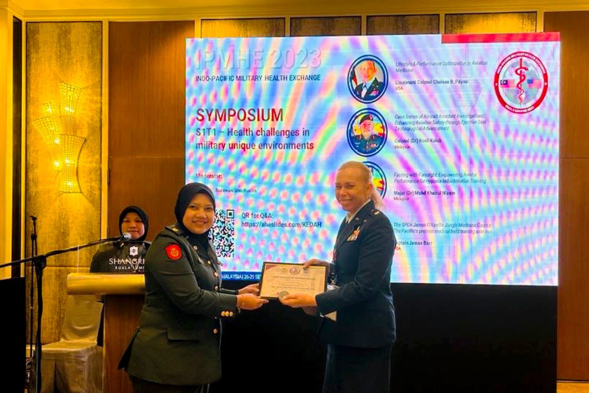 U.S. Air Force Lt. Col. Chelsea Payne, Operational Medical Readiness Squadron commander, receives a certificate after her presentation on Lifestyle and Performance Medicine in Aviation during the 2023 Indo-Pacific Health Exchange in Kuala Lumpur, Malaysia.