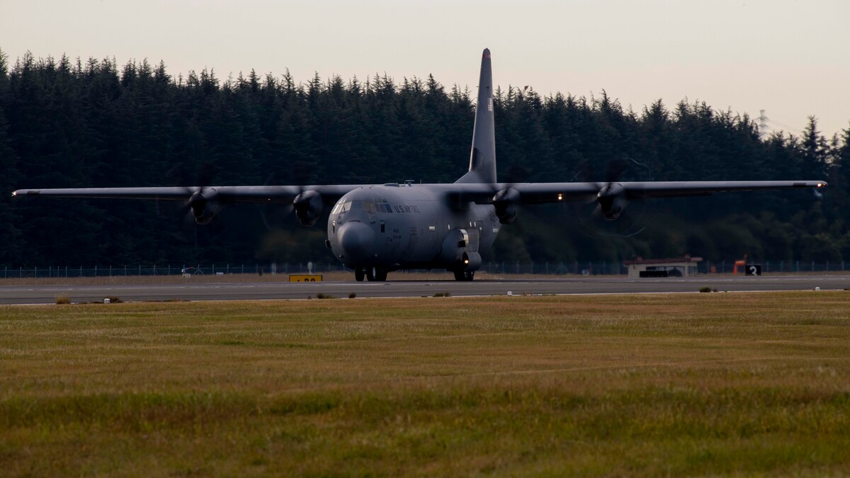A military plane prepares to take off down a runway.