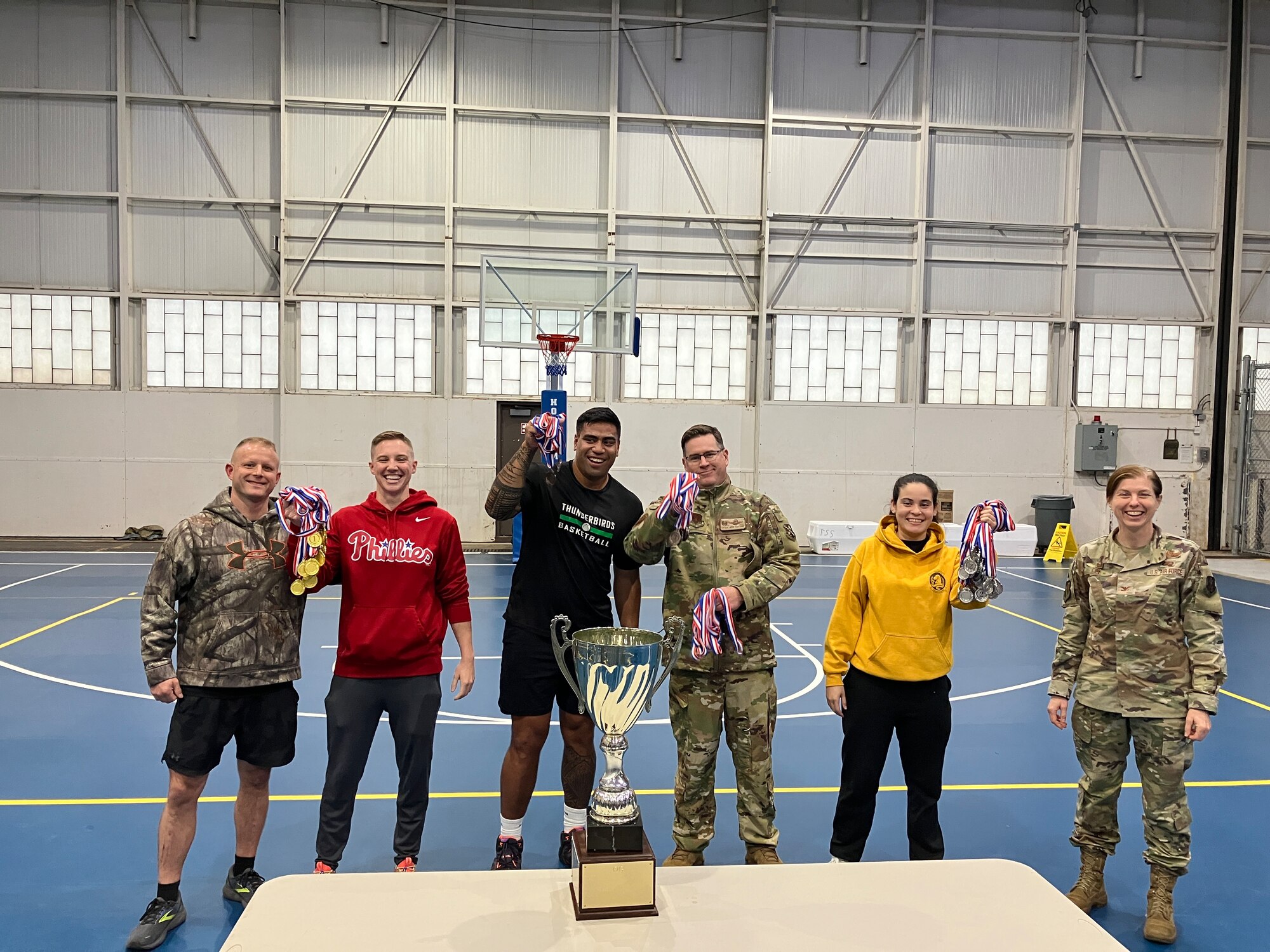 people pose holding a trophy and ribbons.