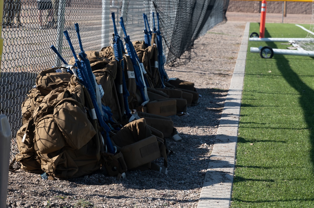 Supply backpacks and training weapons for a Combat Rescue Officer Phase II training exercise are situated in Bama Park at Davis- Monthan Air Force Base, Ariz., Oct. 16, 2023. Proper usage of supplies was a factor that assessed Candidates’’ abilities during the exercise. (U.S. Air Force photo by Airman 1st Class Robert Allen Cooke III)