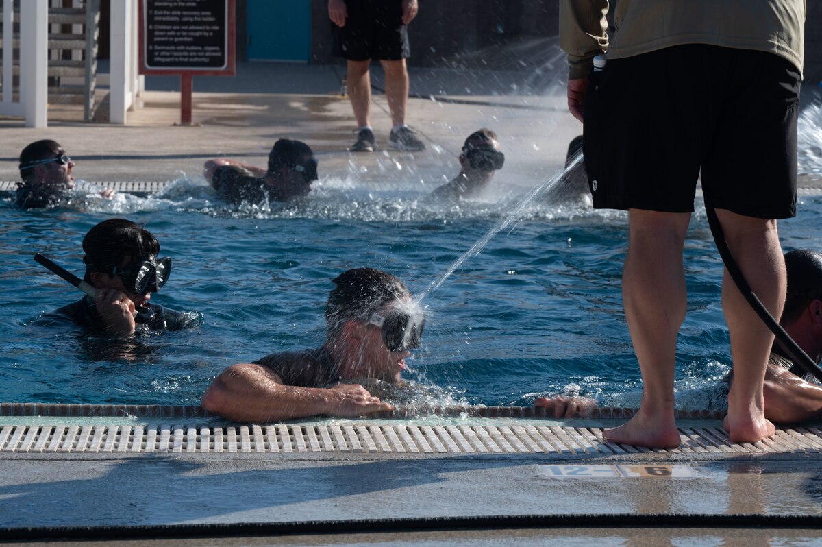 Combat Rescue Officer candidates participate in a Phase II training exercise and practice snorkeling drills in the outdoor pool at Davis-Monthan Air Force Base, Ariz., Oct. 17, 2023. Candidates ability to handle stress management was assessed during the exercise. (U.S. Air Force photo by Airman 1st Class Robert Allen Cooke III)