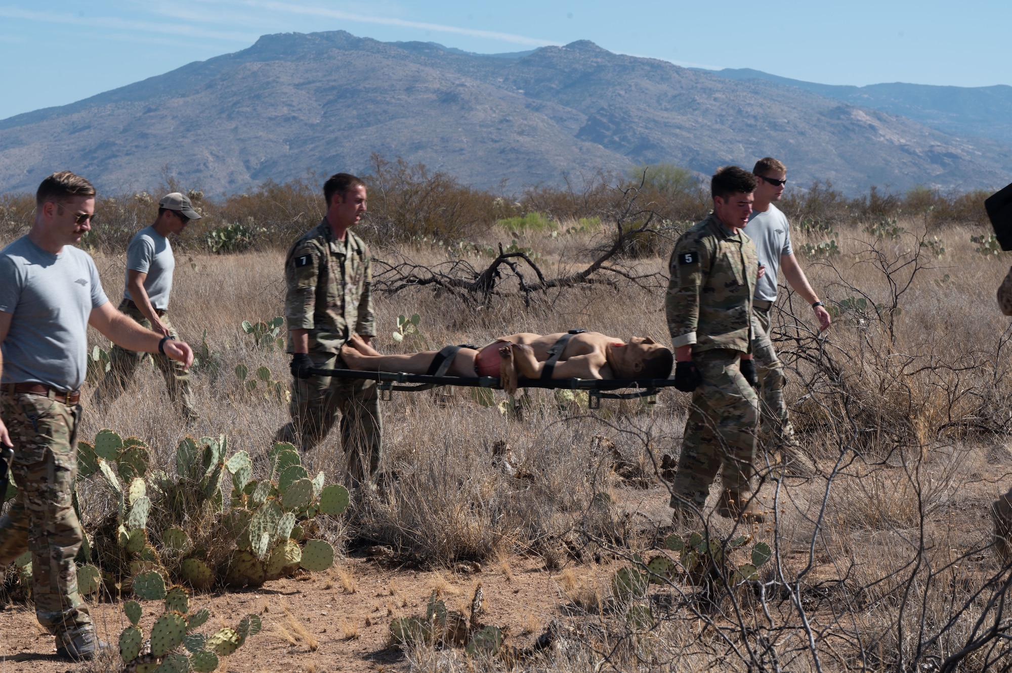 Candidates participating in a Combat Rescue Officer Phase II training exercise simulate a rescue mission at Davis-Monthan Air Force Base, Ariz., Oct. 18, 2023. Candidates carried a dummy on a stretcher to a vantage point to simulate injury response techniques. (U.S. Air Force photo by Airman 1st Class Robert Allen Cooke III)