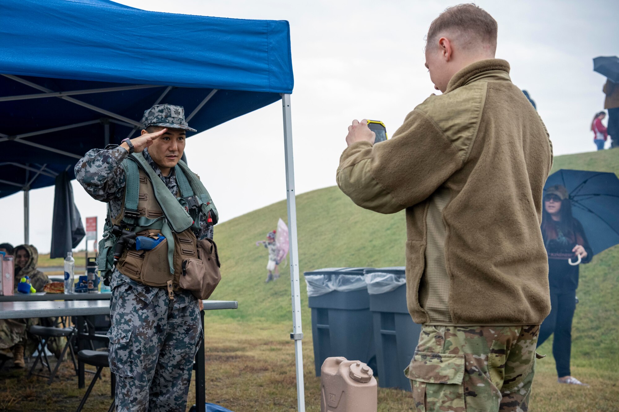 A Japan Air Self-Defense Force Airman poses for a photo while wearing flight gear during Misawa Range Day at Draughn Range, Japan, Oct. 20, 2023.