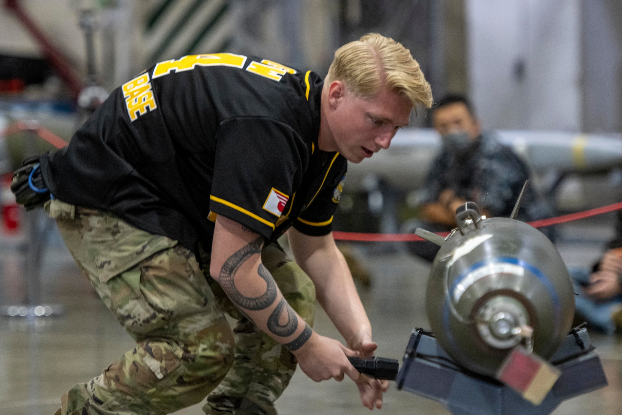 A U.S. Air Force Airman assigned to the 14th Fighter Generation Squadron, inspects a munition before loading it onto an F-16 Fighting Falcon during a loading demonstration at Misawa Air Base, Japan, Oct. 20, 2023.