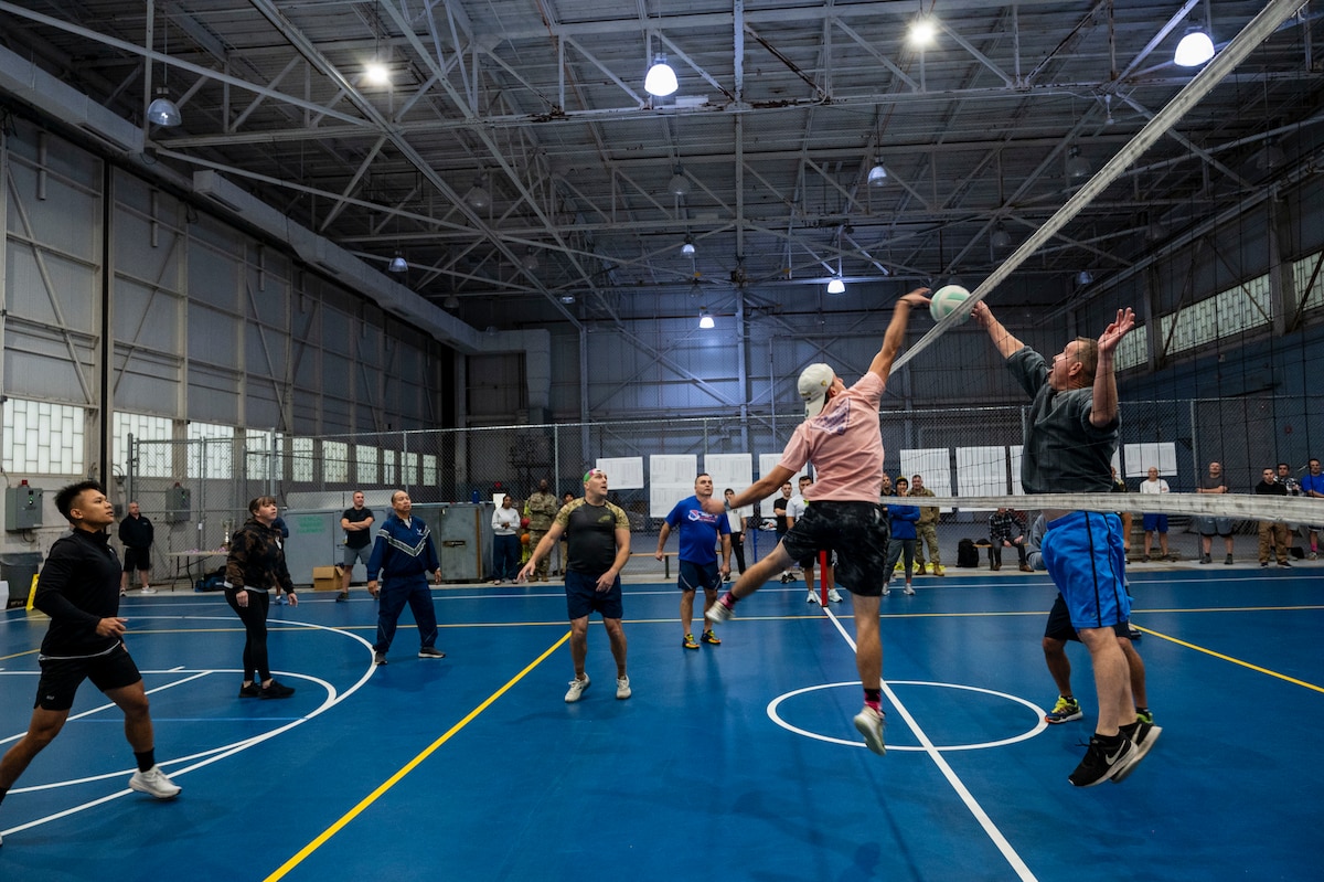 People playing volleyball indoors.