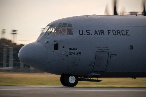 A military plane rolls down a runway.