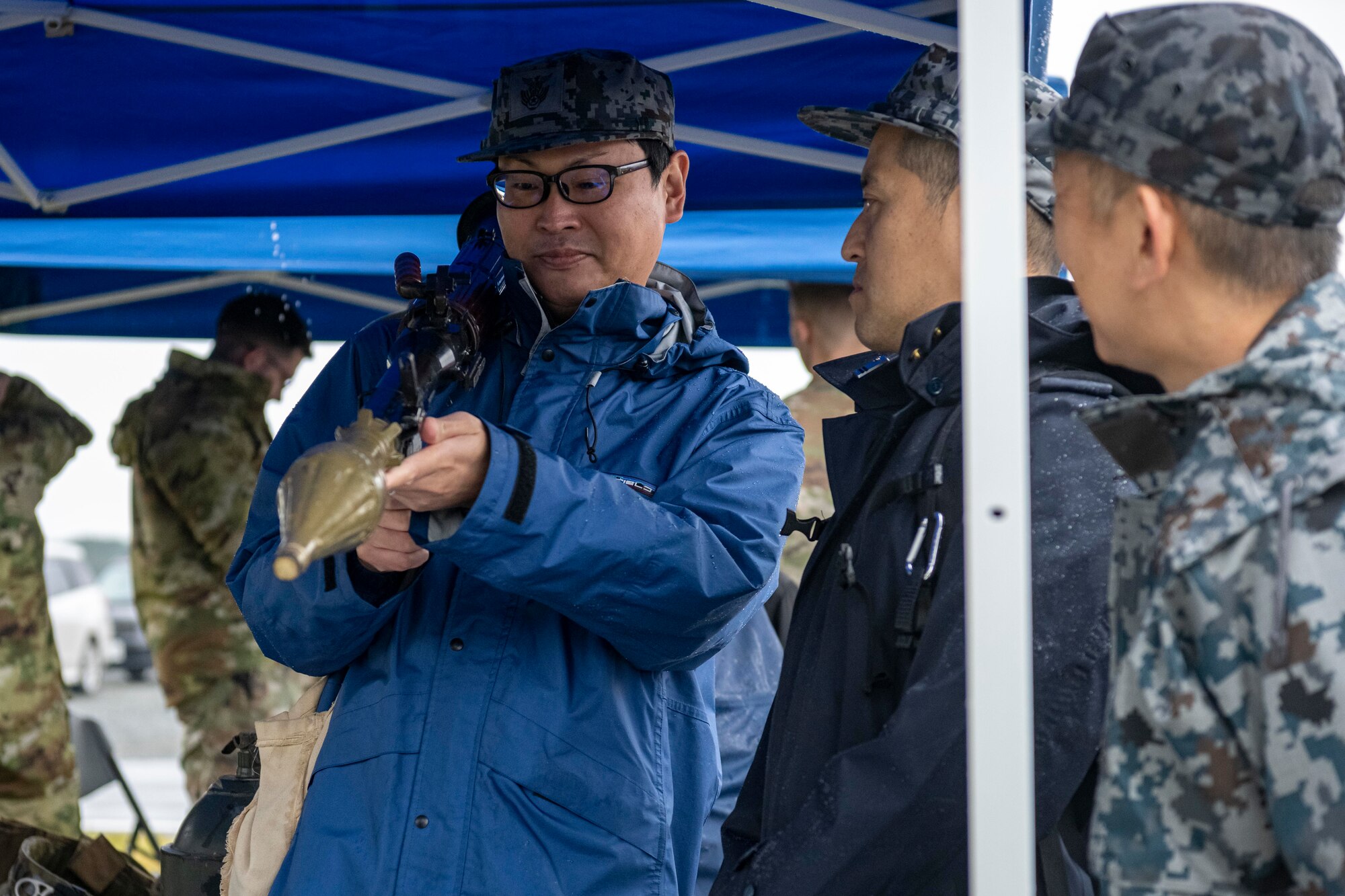 Japan Air Self-Defense Force Airmen look at a Rocket Propelled Grenade launcher at the Explosive Ordnance Disposal tent during Misawa Range Day at Draughn Range, Japan, Oct. 20, 2023.