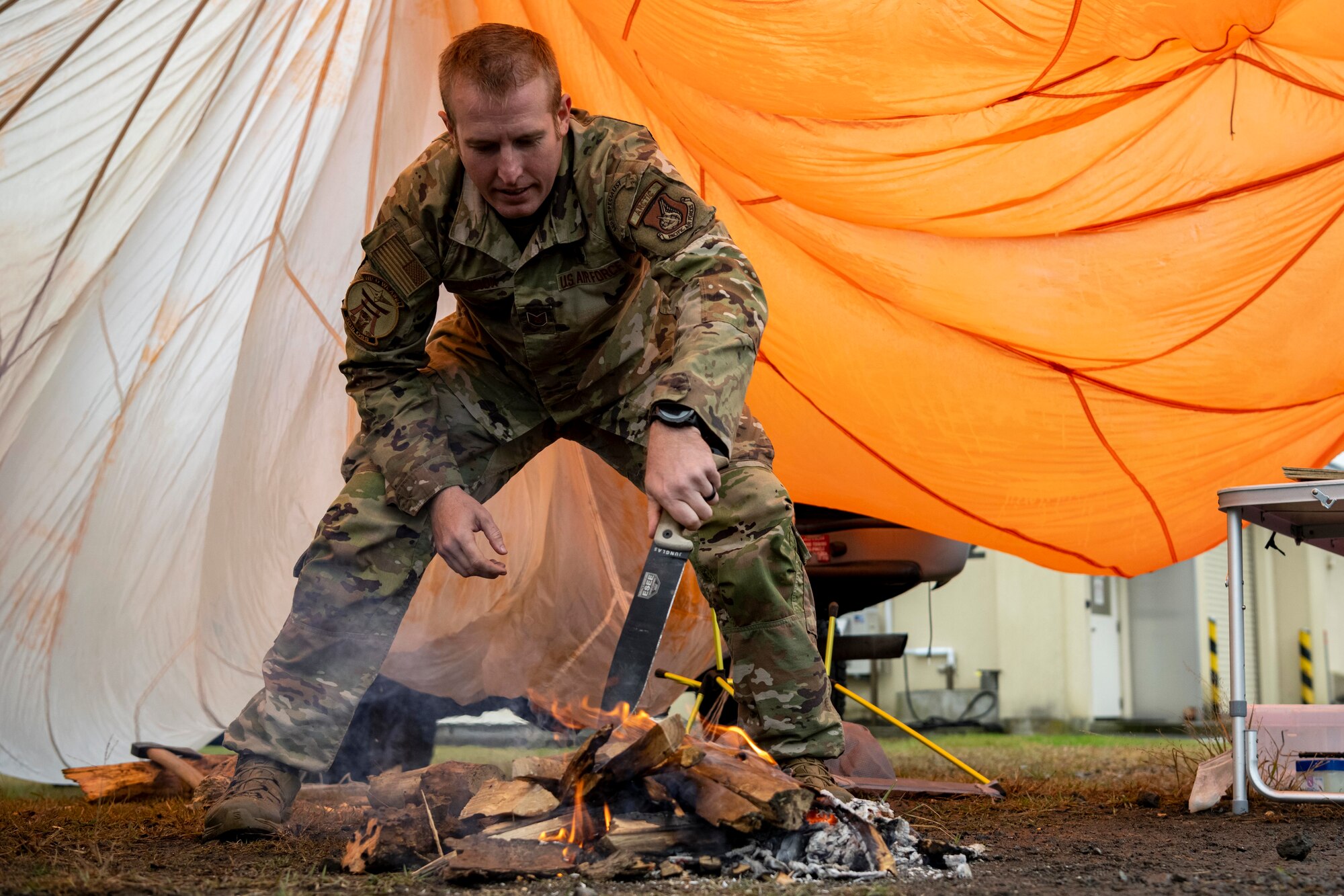 A Survival, Evasion, Resistance Escape (SERE) specialist tends to a fire during Misawa Range Day at Draughn Range, Japan, Oct. 20, 2023.