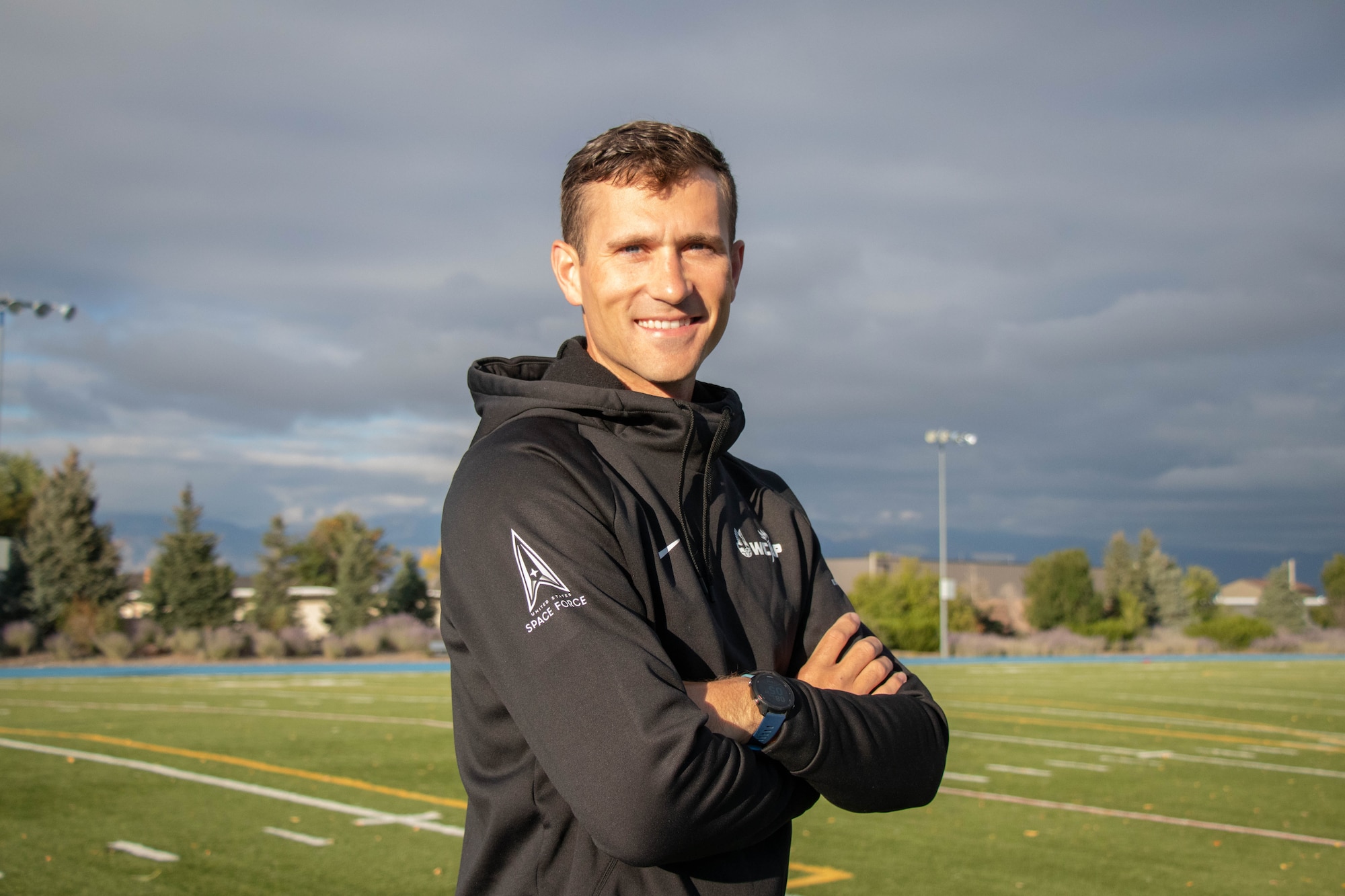 The Air Force World Class Athlete Program’s Airman 1st Class Daniel Michalski sports a WCAP sweatshirt before completing warm-up laps at Peterson Space Force Base, Colorado, Oct. 6, 2023. Michalski competes in the men’s 3,000-meter steeplechase nationally and abroad in the hopes of qualifying for the 2024 Olympics in Paris, France. (U.S. Space Force photo by Emily Peacock)