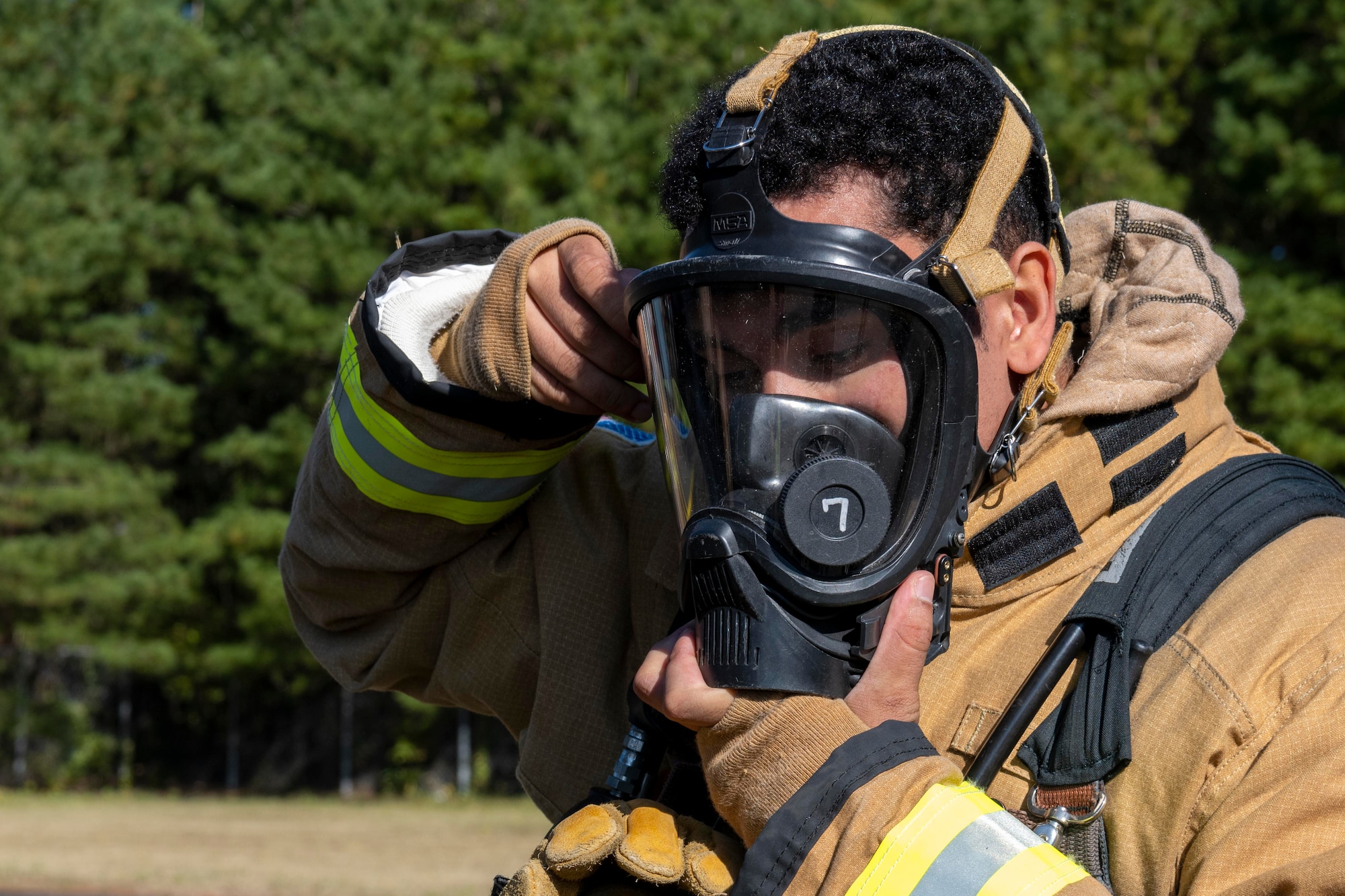 A firefighter dons a firefighter mask.
