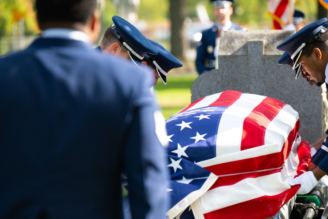 Airmen carry a flag-draped casket during a funeral ceremony.