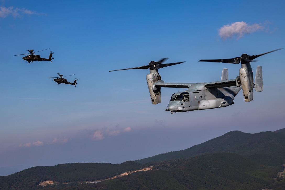 A U.S. Marine Corps MV-22 Osprey tiltrotor aircraft with Marine Medium Tiltrotor Squadron 262, Marine Aircraft Group 36, 1st Marine Aircraft Wing, conducts a bilateral formation flight alongside Japan Ground Self-Defense Force AH-64 Apaches with 1st Squadron, 1st Combat Helicopter Battalion, Western Army Aviation Group, during the field training exercise portion of Resolute Dragon 23 over Kumamoto, Japan, Oct. 18, 2023. RD 23 is an annual bilateral exercise in Japan that strengthens the command, control, and multi-domain maneuver capabilities of Marines in III Marine Expeditionary Force and allied Japan Self-Defense Force personnel.