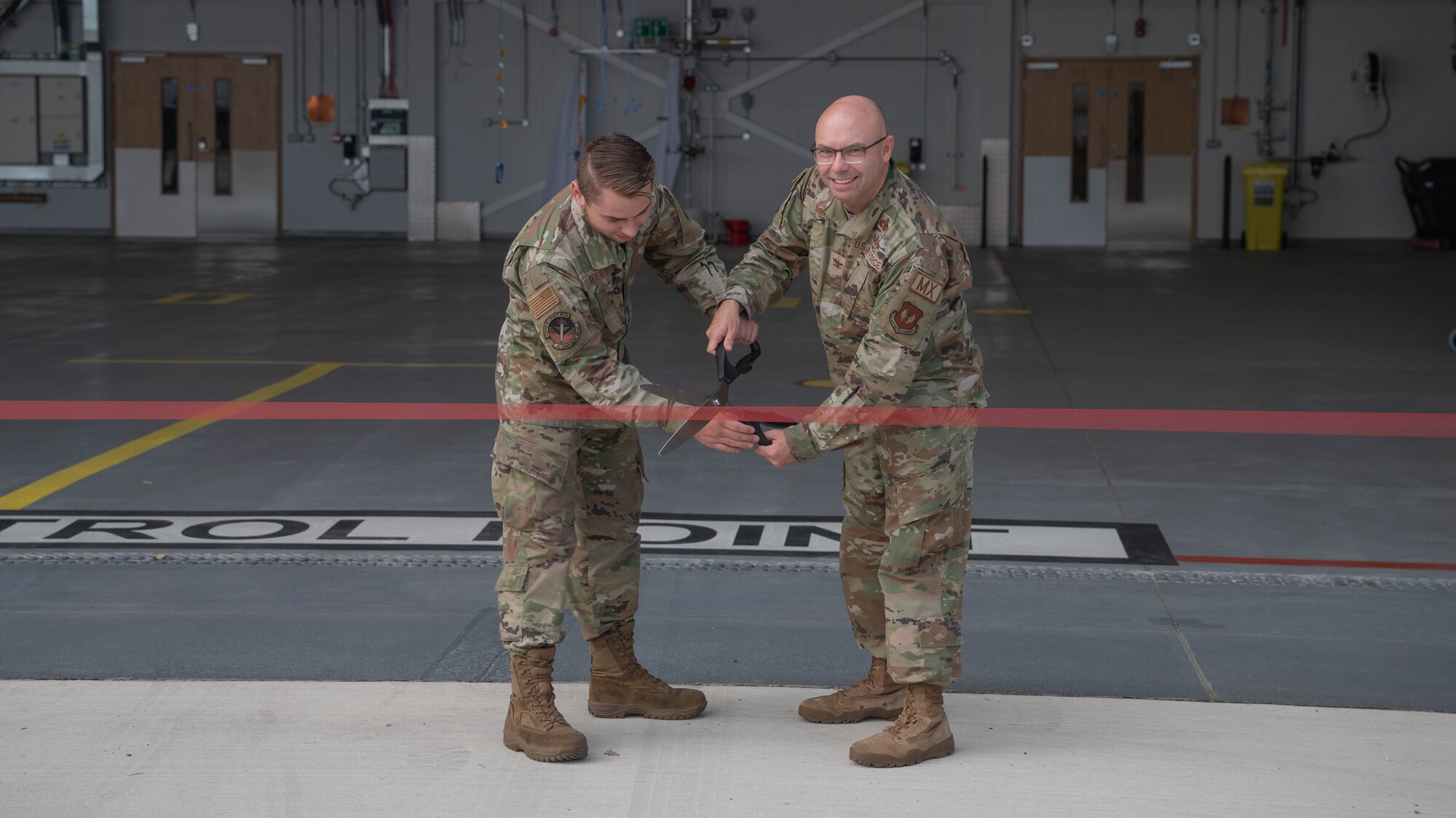 commander and airmen cut a ribbon opening the facility