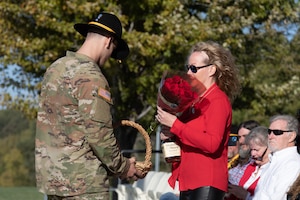 Crystal Barker, wife of U.S Army Command Sgt. Maj. Jeffery Barker, the outgoing command sergeant major of 5th Squadron, 4th Calvary Regiment, 1st Infantry Division, receives a bouquet of red roses during a Change of Responsibility Ceremony on Oct. 11, 2023, at Fort Riley, Kansas, Cavalry Parade Field. The roses are given as a gift for the sacrifices she’s made during her husband’s military career. (U.S. Army Photo by Pfc. Koltyn O’Marah)