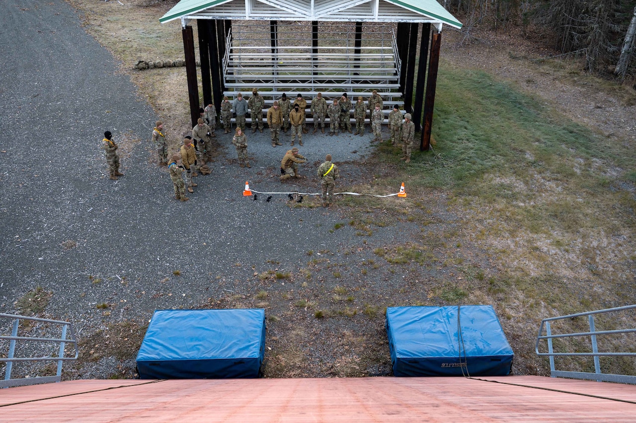 Overhead view of soldiers standing in front of a rappelling wall.