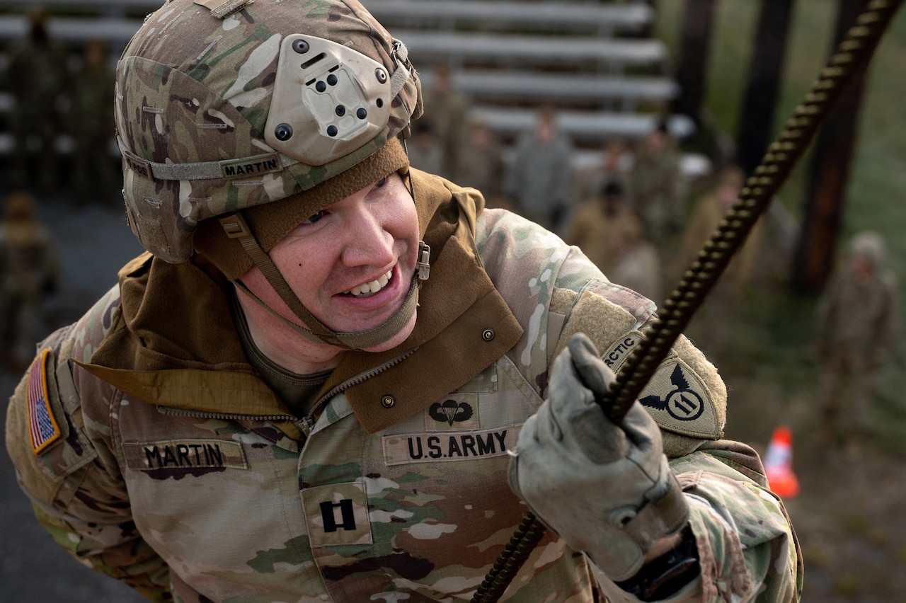 A smiling uniformed service member participates in rappel training.