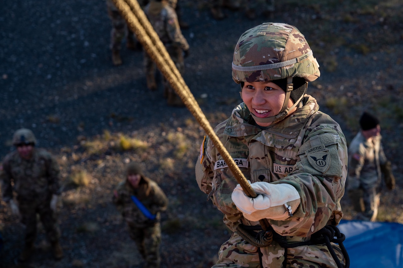 A smiling uniformed service member participates in rappel training.