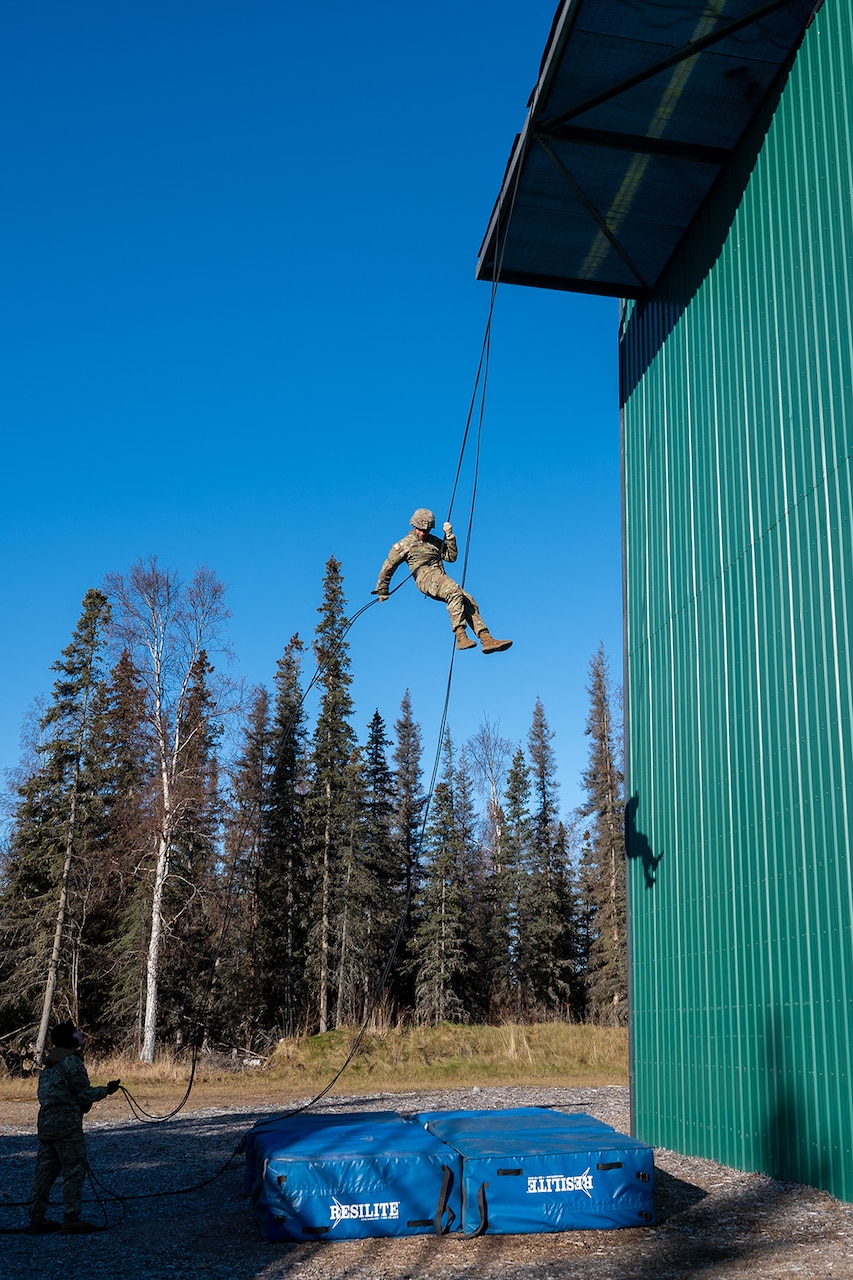 A uniformed service member participates in rappel training.