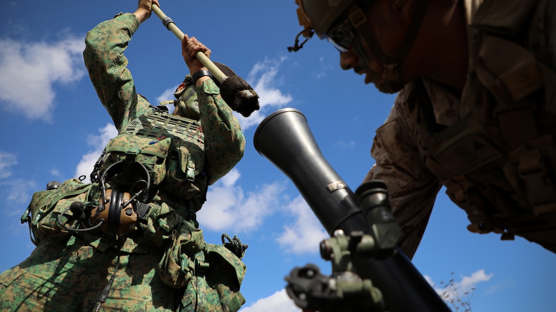 Singapore Guardsmen PTE Avi Gangla, left, a mortar operator with the 7th Singapore Infantry Brigade, and U.S. Marine Corps Lance Cpl. Angel Martinez, a mortarman with 2nd Battalion, 4th Marine Regiment, 1st Marine Division, operate a M252A2 81mm mortar system during a mortar live fire range as part of Exercise Valiant Mark 2023 at Camp Pendleton, CA, Oct. 11, 2023. Valiant Mark 2023 is an annual, bilateral training exercise conducted between the Singapore Armed Forces and I Marine Expeditionary Force, designed to enhance interoperability, improve combined arms and amphibious warfighting skills, and strengthen military-to-military relationships. (U.S. Marine Corps photo by Sgt. Quince D. Bisard)