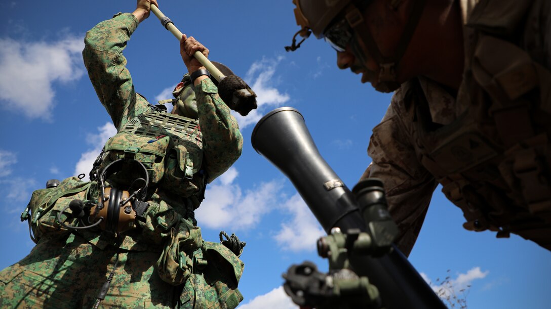 Singapore Guardsmen PTE Avi Gangla, left, a mortar operator with the 7th Singapore Infantry Brigade, and U.S. Marine Corps Lance Cpl. Angel Martinez, a mortarman with 2nd Battalion, 4th Marine Regiment, 1st Marine Division, operate a M252A2 81mm mortar system during a mortar live fire range as part of Exercise Valiant Mark 2023 at Camp Pendleton, CA, Oct. 11, 2023. Valiant Mark 2023 is an annual, bilateral training exercise conducted between the Singapore Armed Forces and I Marine Expeditionary Force, designed to enhance interoperability, improve combined arms and amphibious warfighting skills, and strengthen military-to-military relationships. (U.S. Marine Corps photo by Sgt. Quince D. Bisard)