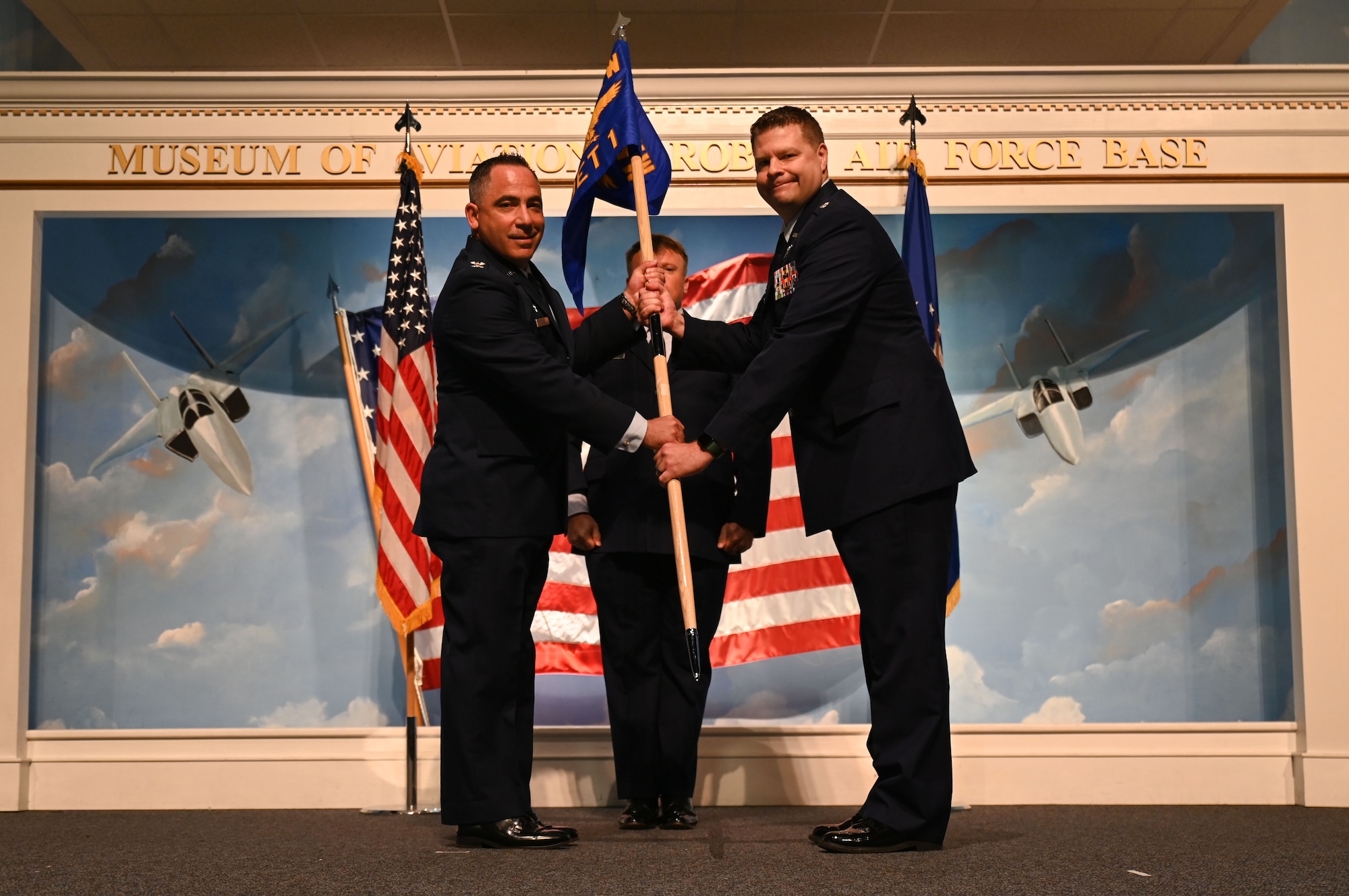 U.S. Air Force Col. Josh Koslov, 350th Spectrum Warfare Wing commander, left, passes the 87th Electronic Warfare Squadron Det 1 guidon to U.S. Air Force Lt. Col. Christopher Ryan Cox, 350th SWW, Det 1 and 87th Electronic Warfare Squadron, Det 1 commander, right, at Robin Air Force Base, GA, Oct. 25, 2023. The activation of the 87th EWS Det 1 represents the Air Force’s response to years of stagnation in EMS capabilities, charged with increasing the lethality of warfighters. (U.S. Air Force photo by Staff Sgt. Ericka A. Woolever)