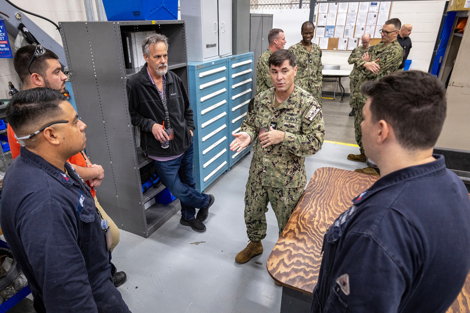 Capt. JD Crinklaw, commander, Puget Sound Naval Shipyard & Intermediate Maintenance Facility, visits with Sailors and civilian employees in the electronics shop Oct. 16, 2023, during a visit to PSNS & IMF Detachment Everett. Crinklaw also met with senior leaders to discuss daily operations. (U.S. Navy photo by Scott Hansen)