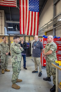 Capt. JD Crinklaw, commander, Puget Sound Naval Shipyard & Intermediate Maintenance Facility, visits with Sailors and employees as he tours the Close-in Weapons Systems repair shop Oct. 16, 2023, during a tour of PSNS & IMF Detachment Everett, Washington. Crinklaw also toured the tool room, Electronics shop and the Shop 31D Pump/Valve repair shop during his visit. (U.S. Navy photo by Scott Hansen)