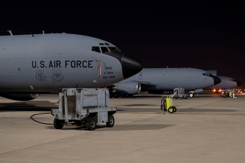 Aircraft are parked in a row on a flight line.