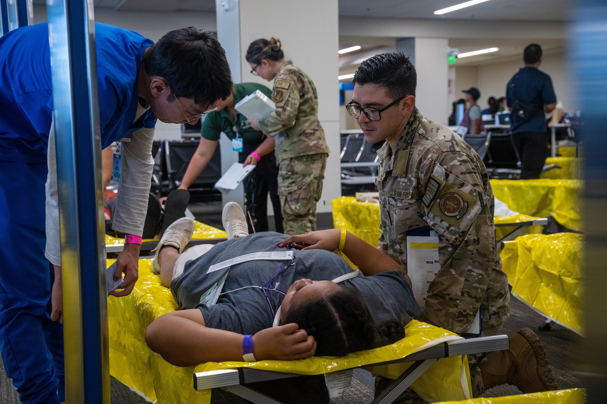 Tech Sgt. Jeffrey Rodriguez, 535th Airlift Squadron Medical Element noncommissioned officer in charge, coaches nursing students tending to simulated patients during the triennial airport disaster exercise at Daniel K. Inouye International Airport, Oct. 20, 2023. Airmen assigned to the 15th Medical Group observed nursing students from across the island and answered questions and gave advice about different possible medical scenarios. (U.S. Air Force photo by Senior Airman Makensie Cooper)