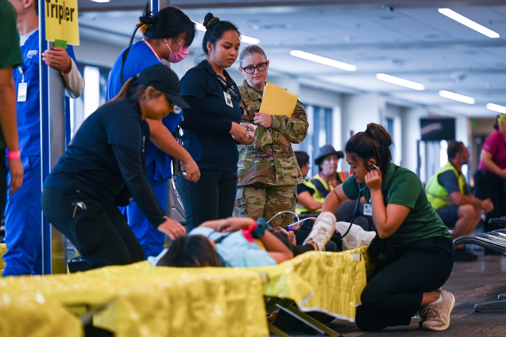 Tech Sgt. Anna Daily 15th Healthcare Operations flight Primary Care flight chief, observes nursing students tend to a simulated patient during the triennial airport disaster exercise at Daniel K. Inouye International Airport, Oct. 20, 2023. This simulated full-scale aircraft emergency disaster exercise is a mandatory certification requirement by the Federal Aviation Administration that tests airfield disaster response and preparedness. (U.S. Air Force photo by Senior Airman Makensie Cooper)