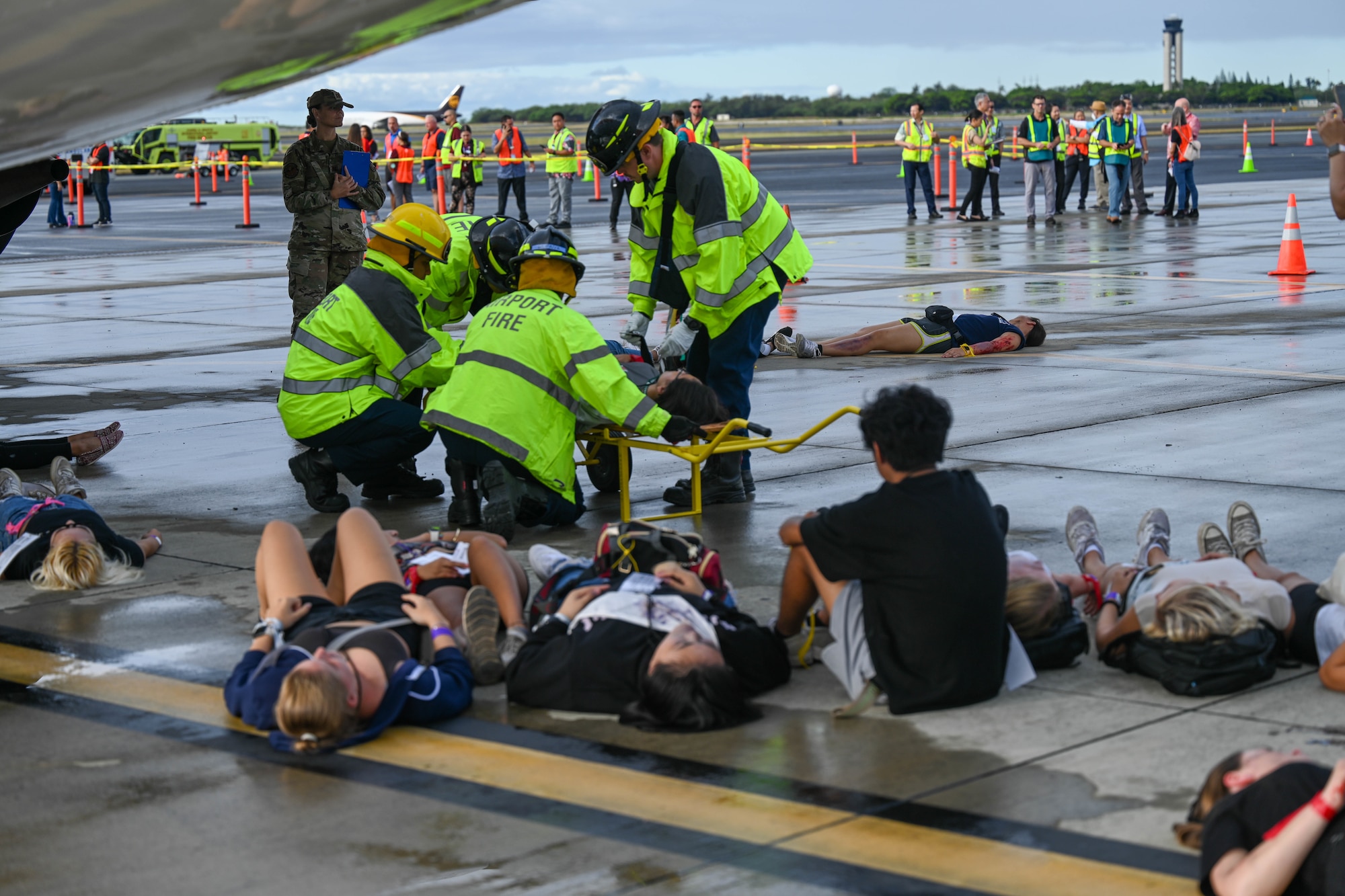 Capt. Ursula Hall, 15th Healthcare Operations Flight Pediatrics element chief observes as first responders tend to simulated patients during a triennial airport disaster exercise at Daniel K. Inouye International Airport, Oct. 20, 2023. This simulated full-scale aircraft emergency disaster exercise is a mandatory certification requirement by the Federal Aviation Administration that tests airfield disaster response and preparedness. (U.S. Air Force photo by Senior Airman Makensie Cooper)