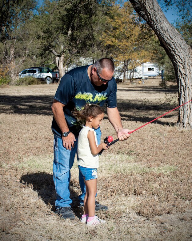 HASTY, Colo., -- A young girl learns how to cast a fishing line with the help of her grandfather at the fishing derby event. The fishing derby was one of several events organized by USACE John Martin staff in celebration of the 75th anniversary of John Martin Dam and Reservoir, Oct. 21, 2023.