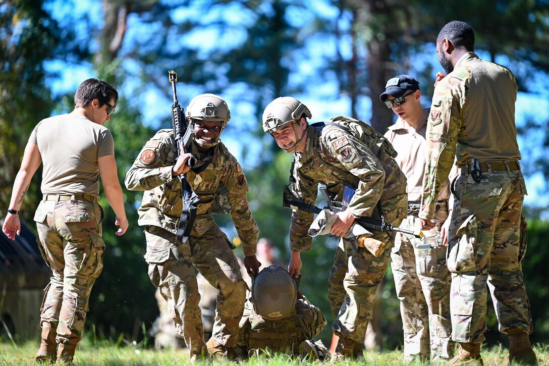 Two Airmen drag a simulated patient while under evaluation.