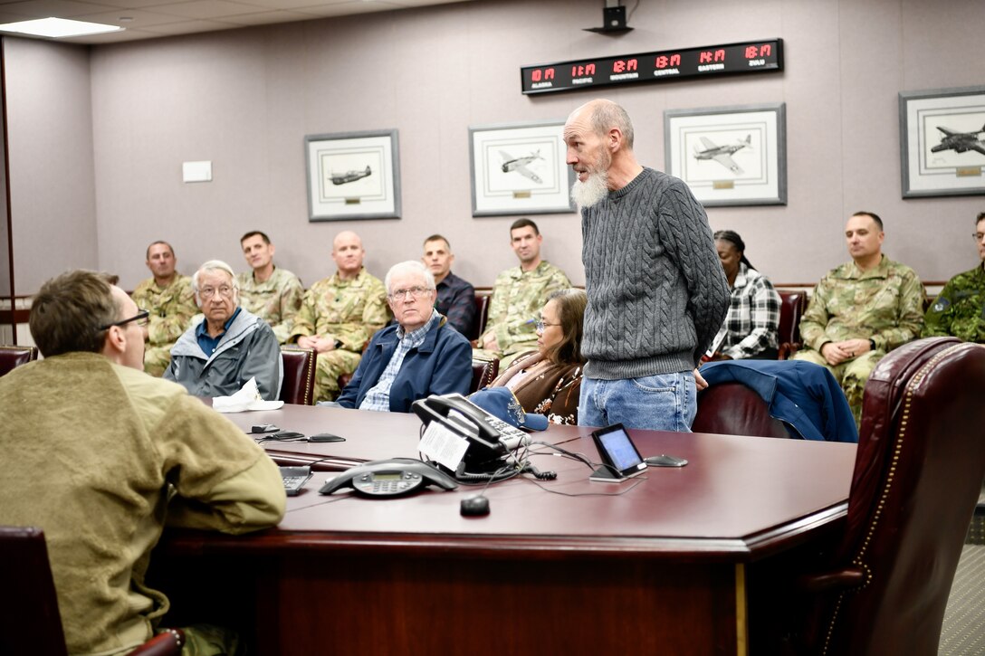 Men standing talking about his service at the 25th Air Division