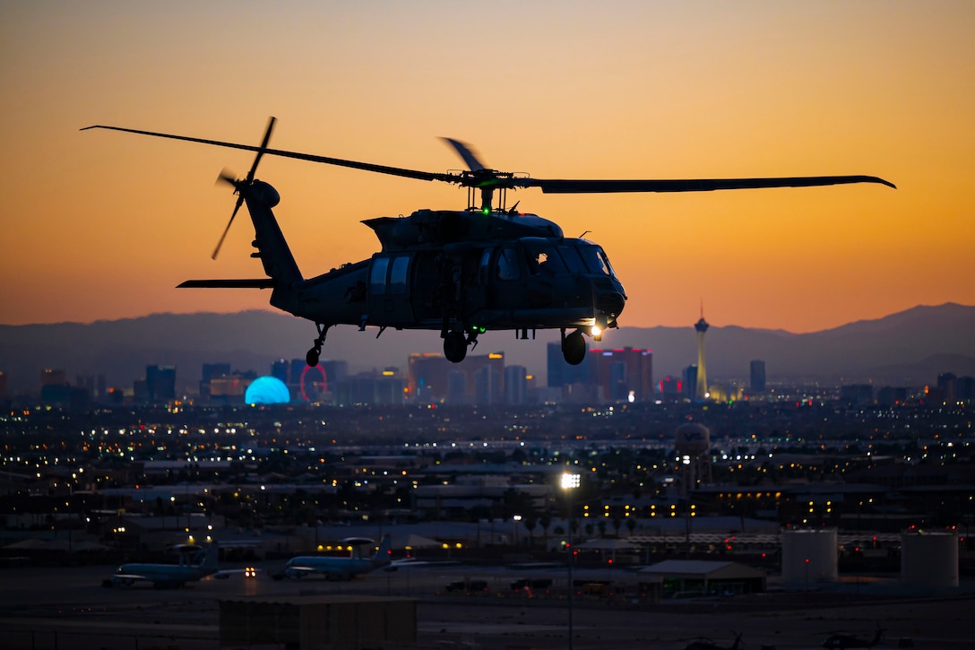 A helicopter flies above a city at twilight.