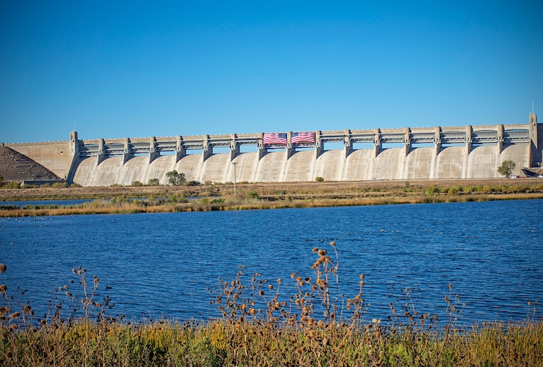 John Martin Dam with two American flags. Lake Hasty is seen in the foreground. The dam celebrated its 75-year diamond anniversary, Oct. 21, 2023.