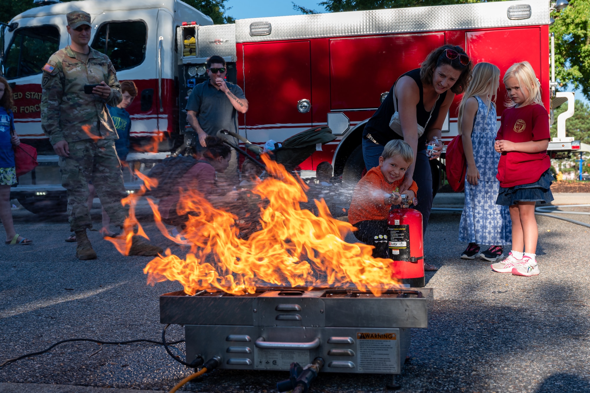 Child puts out a controlled fire with a fire extinguisher