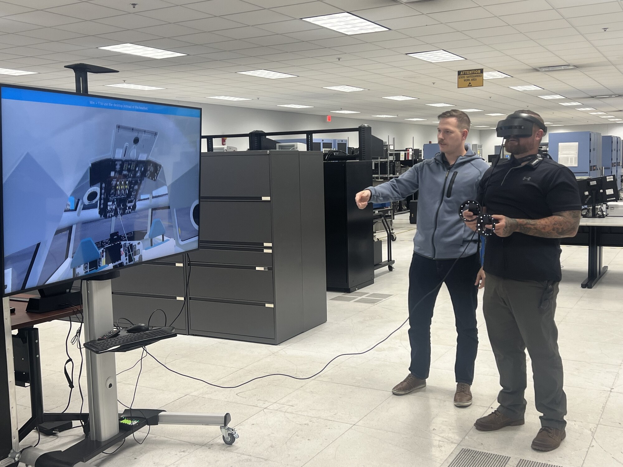 Joshua Postlewait (right), Legacy Tanker Division, Foreign Military Sales, demonstrating the virtual reality KC-135 VMT with assistance from Joseph Lucas with the 555 Software Engineering Squadron.