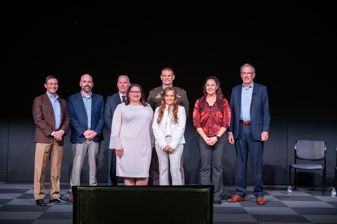 A group of people pose for a photograph on a stage.