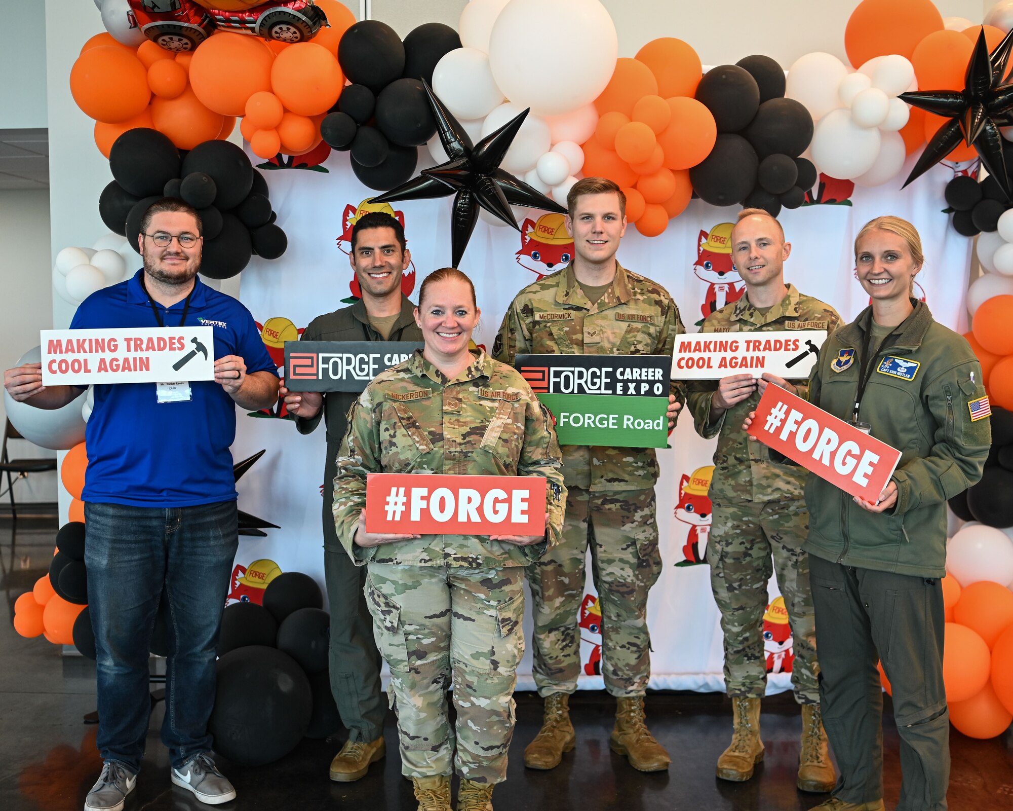 Columbus Air Force Base personnel pose with different FORGE signs from the FORGE event hosted at East Mississippi Community College October 25, 2023.