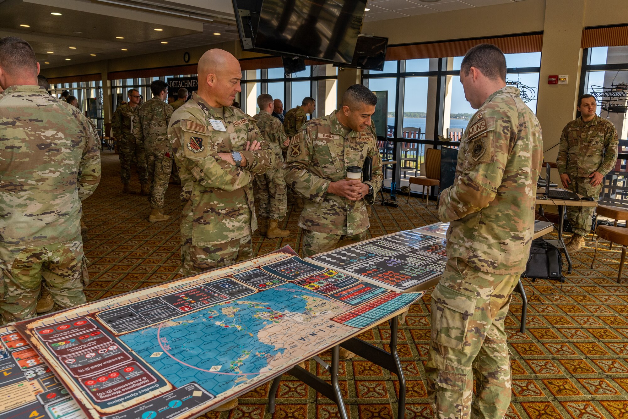 U.S. Air Force Capt. Keith Gregorcyk, 363rd Training Squadron, maintenance officer intermediate instructor, shows off a board game called Kingfish Ace to Brig. Gen. George Dietrich III, 82nd Training Wing commander, and Command Master Sgt. Carlos Damian, 37th Training Wing command chief, during Technical Training 101 at Keesler Air Force Base, Oct. 25, 2023.