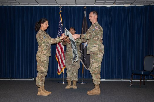  U.S. Space Force Col. Nicole Petrucci, commander of Space Delta 3 – Space Electromagnetic Warfare (left), and Maj. Zachary Scoggins, commander of the 23rd Electromagnetic Warfare Squadron (right), unravel the 23rd EWS’s official guidon for the first time during the squadron’s activation ceremony on Peterson Space Force Base, Colorado, Oct. 16, 2023. The 23rd EWS became the 5th squadron to fall under DEL 3. (U.S. Space Force photo by Emily Peacock)