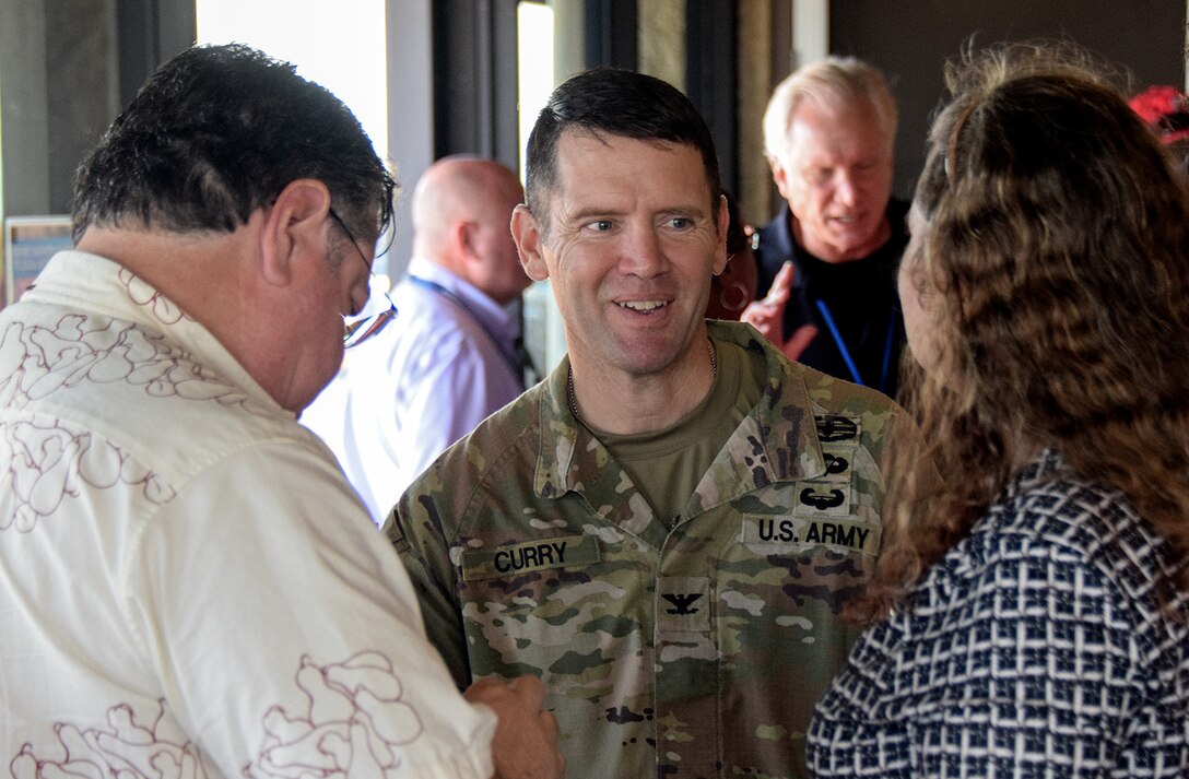 Army officer speaks with committee public after meeting.