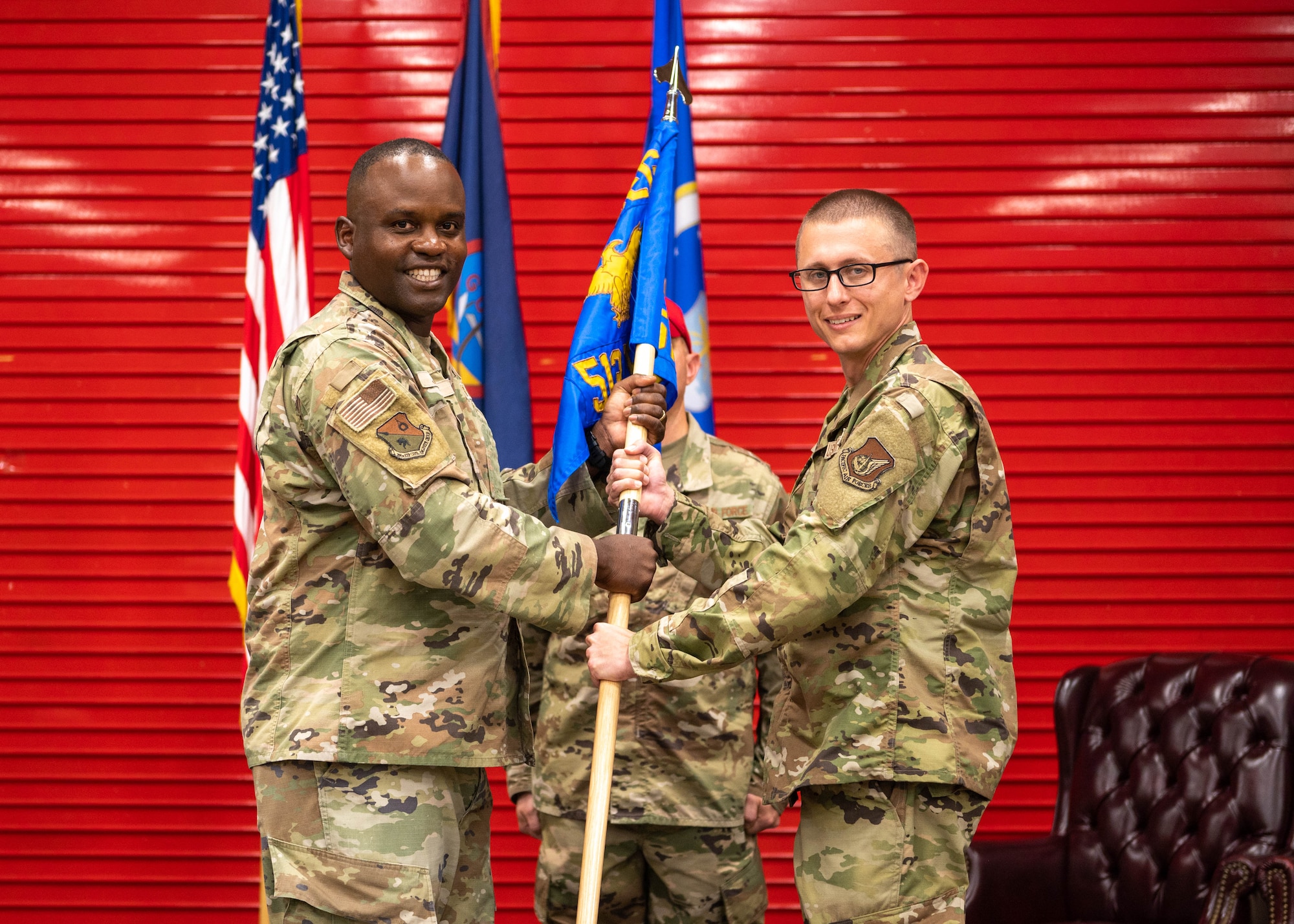 U.S. Air Force Col. Kenneth Joseph, commander of the 356th Expeditionary Civil Engineer Group, passes the guidon to Maj. Chrystopher Nicholson, commander of the 513th Rapid Engineer Deployable Heavy Operations Repair Squadron Engineers Squadron, at the Pacific Regional Training Center – Andersen, Guam, Oct. 20, 2023. Nicholson assumed command of the 513th RHS. (U.S. Air Force photo by Airman Allon Lapaix)