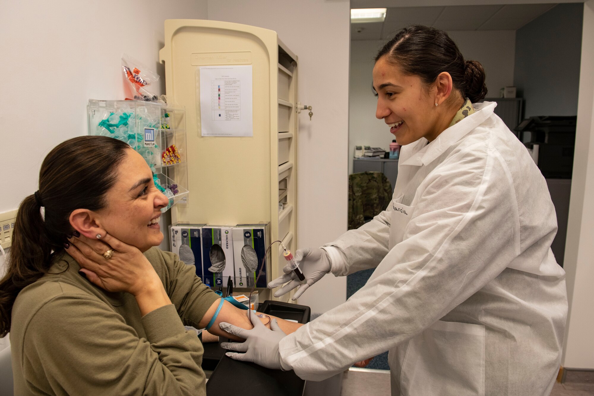 Staff Sgt. Gisele Garcia, 423d Medical Squadron medical laboratory technician, right, draws blood from Master Sgt. Yara Hernandez, 501st Combat Support Wing executive services superintendent, at RAF Alconbury