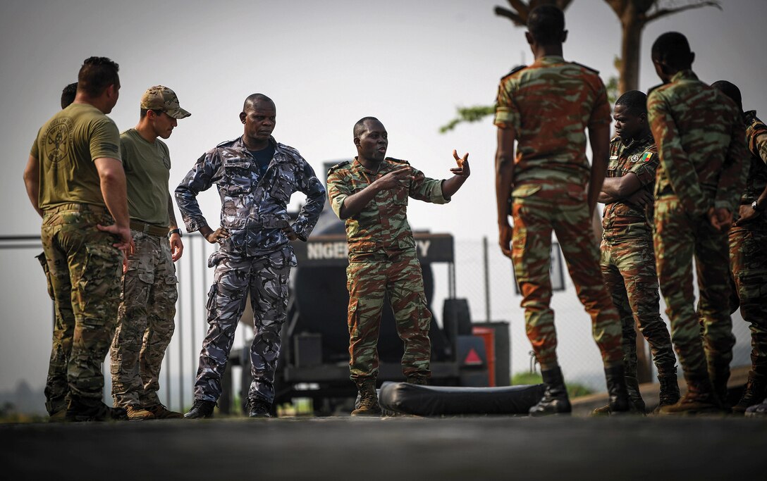 Benin navy Maitre Major Hermann Hungije addresses Benin navy and police force personnel and U.S. Coast Guard personnel from Law Enforcement Detachment 403 as they conduct close-quarters combat training during Obangame Express 2023, in Lagos, Nigeria, January 25, 2023