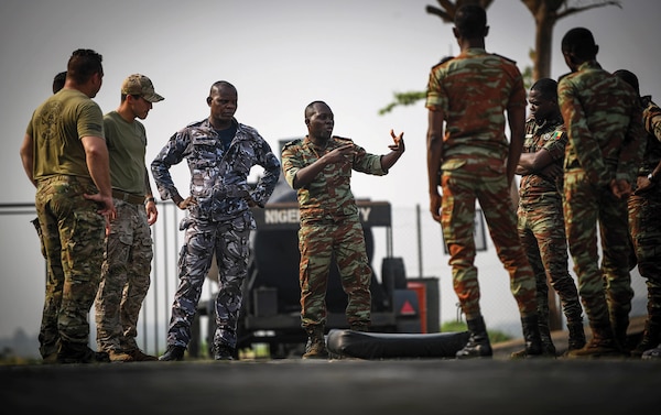 Benin navy Maitre Major Hermann Hungije addresses Benin navy and police force personnel and U.S. Coast Guard personnel from Law Enforcement Detachment 403 as they conduct close-quarters combat training during Obangame Express 2023, in Lagos, Nigeria, January 25, 2023 (U.S. Navy/Cameron C. Edy)