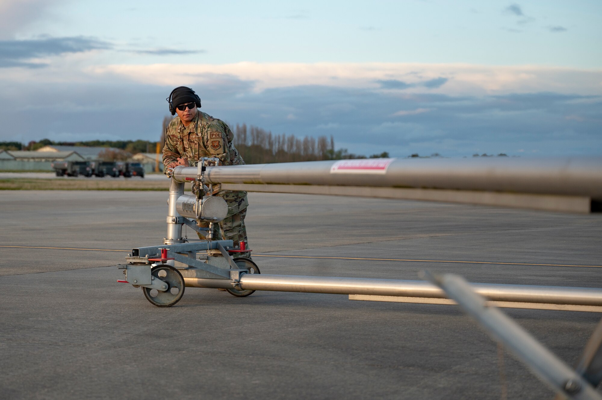 Tech. Sgt. Robert Duarte, 9th Expeditionary Bomb Squadron fuels distribution operator, performs hot pit refueling on a B-1B Lancer at RAF Fairford, United Kingdom, Oct. 27, 2023. The team was using a pantograph for the continuous transport of fuel instead of utilizing fuel trucks, decreasing the time required to refuel. (U.S. Air Force photo by Airman 1st Class Emma Anderson)