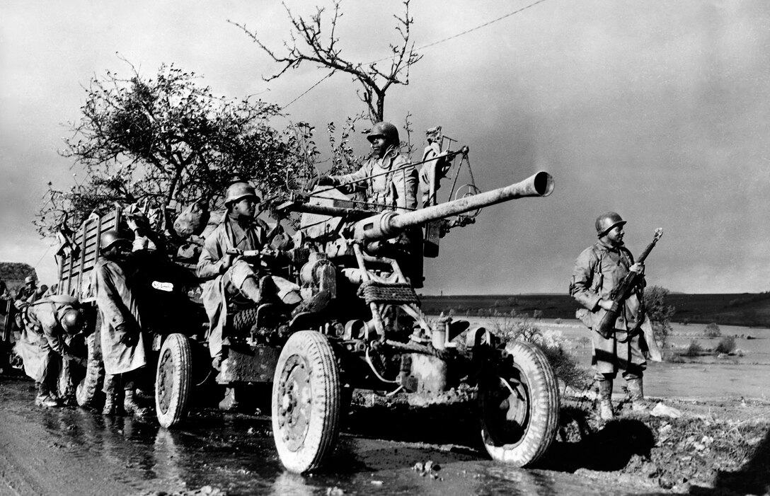 Soldiers with the 452nd Antiaircraft Artillery Battalion stand by and check their equipment during convoy in Belgium, November 4, 1944